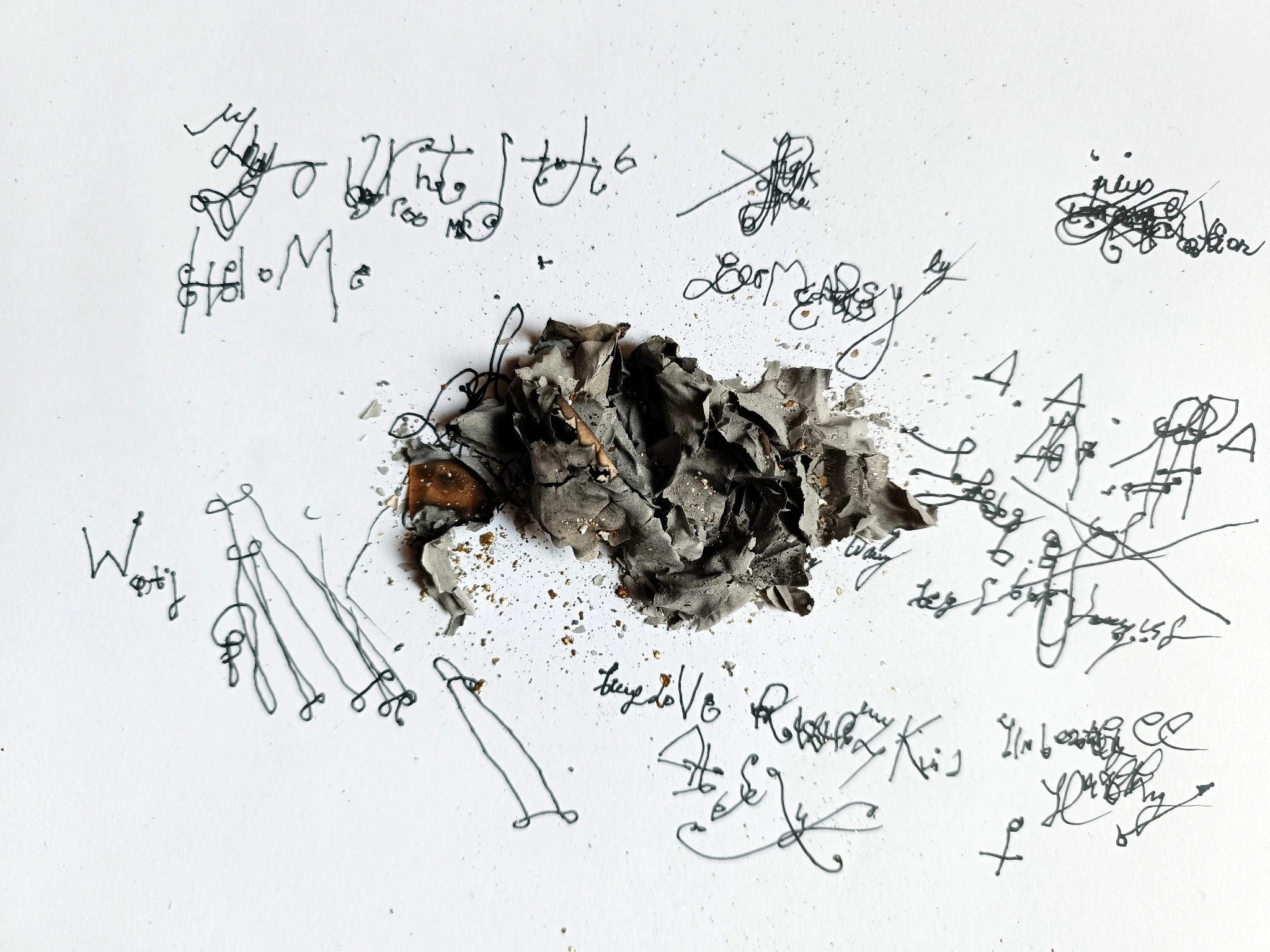 Dark sculptural cluster surrounded by handwritten signs on white paper